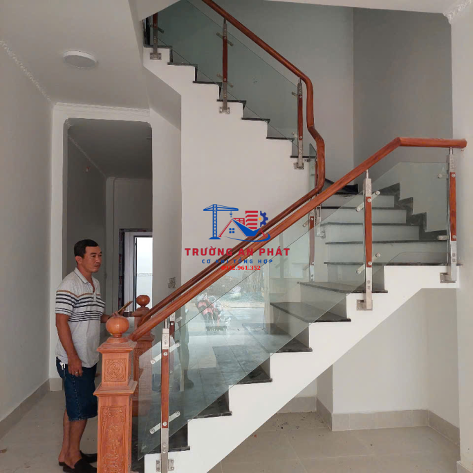 Cầu thang kính tay vịn gỗ sang trọng nhà phố